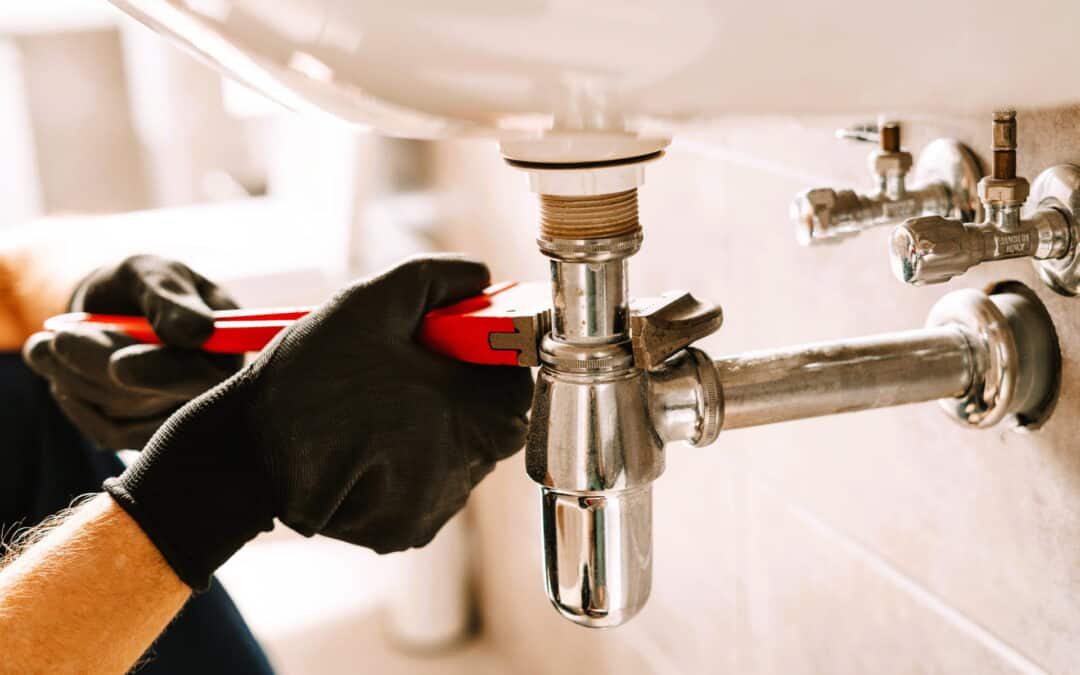 plumber using a wrench repairing a sink