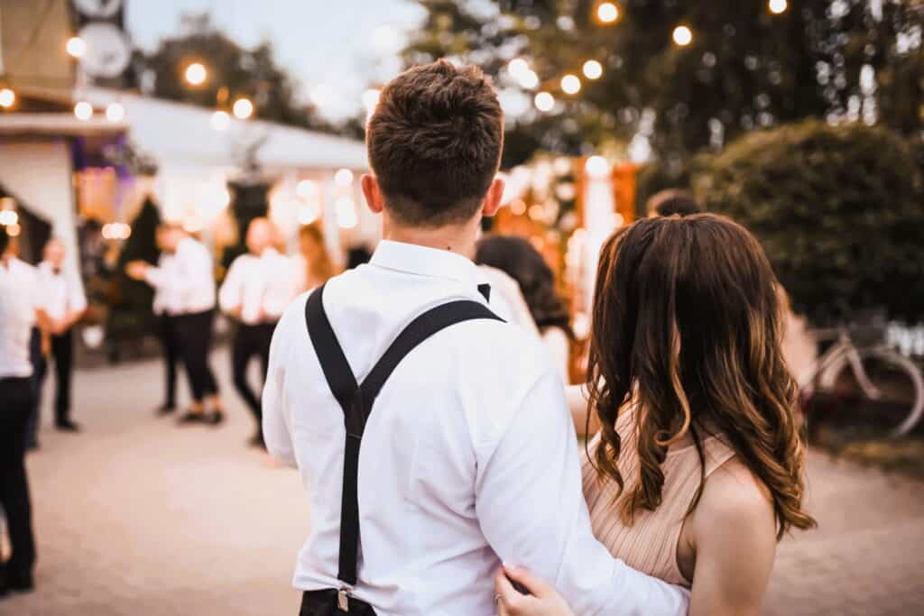 young couple-holding-each-other-at-outdoor-celebration